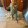 Aurora joined the competition — help win amazing prizes! appliance, baby, child, cute, expression, floor, hair_buns, home, indoors, kitchen, pajamas, person, pointing, rug, small_child, socks, standing, tile_floor, toddler, wooden_cabinets