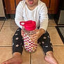 Aurora is registered to the contest to win money with this photo: barefoot, cabinet, checkered_pattern, child, cute, expression, floor, indoors, kitchen, long_sleeve_shirt, pants, person, playful, sitting, smiling_flowers, tile, toddler, tongue_out, water_bottle, wood