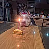 dog, birthday, candle, cake, table, indoor, wooden_table, pet, celebration, cozy, dim_lighting, kitchen, household_items, food, waiting, animal, cute, brown_dog, still_life, relaxing