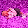 Abigail is registered to the contest to win money with this photo: baby, infant, child, portrait, lying_down, face, eyes_open, clothing, pink, magenta, rug, fluffy, shoes, sneakers, outdoor_style, fashion, cute, home, carpet, photography