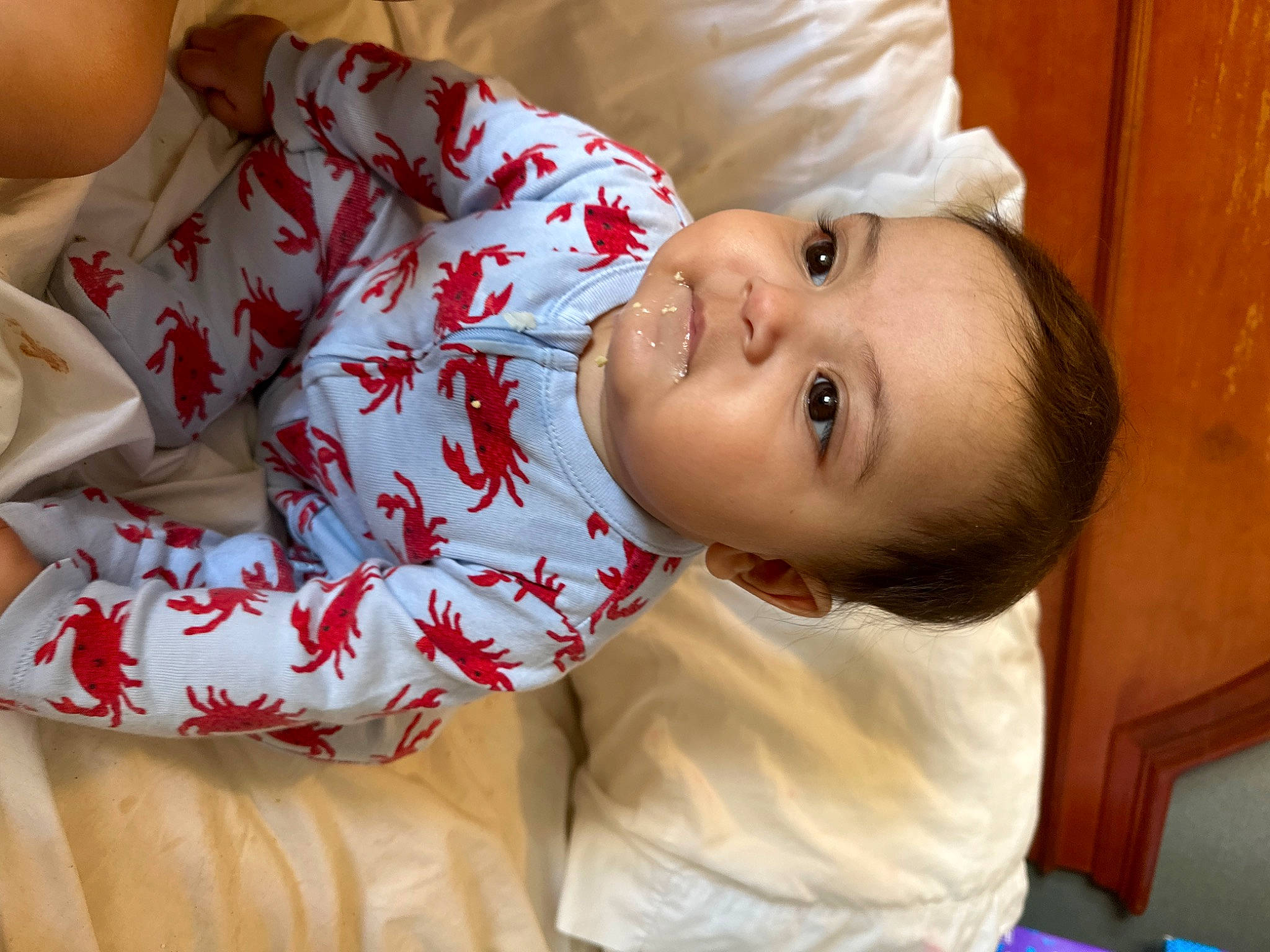 Mateo is registered to the contest to win money with this photo: baby, baby_toddler_clothing, cheek, child, comfort, elbow, flesh, fun, happy, human_leg, linens, lip, nose, pattern, person, portrait_photography, room, skin, sleeve, smile