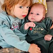 éloïse participe au concours pour gagner de l'argent avec cette photo : child, baby, couch, cushion, clothing, plaid_pants, sweater, infant, toddler, face, eyes, hand, hair, indoor, portrait, sitting, cozy, family, cute, love