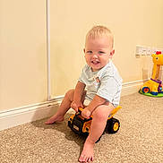 Eric joined the competition — help win amazing prizes! barefoot, blonde_hair, carpet, child, cream_wall, cute, floor, giraffe_toy, happy, indoor, playroom, playtime, short_sleeve_shirt, sitting, smiling, toddler, toy_truck, wall_socket, yellow_toy, young_child