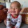 Kassius is registered to the contest to win money with this photo: baby, child, christmas, couch, cozy, cute, face, festive, gingerbread, happy, holiday, home, indoor, infant, pajamas, person, pillow, plush, sitting, smile