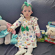 Elyana Desmettre participe au concours pour gagner de l'argent avec cette photo : accessory, bow, child, cushion, dress, easter_theme, glasses, happy_expression, headband, indoors, patterned_dress, plush, portrait, sitting, sofa, stuffed_toy, tights, toddler, toy_box, white_shoes
