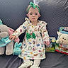accessory, bow, child, cushion, dress, easter_theme, glasses, happy_expression, headband, indoors, patterned_dress, plush, portrait, sitting, sofa, stuffed_toy, tights, toddler, toy_box, white_shoes