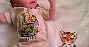 Asaiah joined the competition — help win amazing prizes! animal_design, animal_print, baby, baby_garment, blanket, child, clothing, cute, happy, indoor, infant, lying_down, milestone, one_month, onesie, portrait, smiling, soft_texture, tiger_illustration, young_child