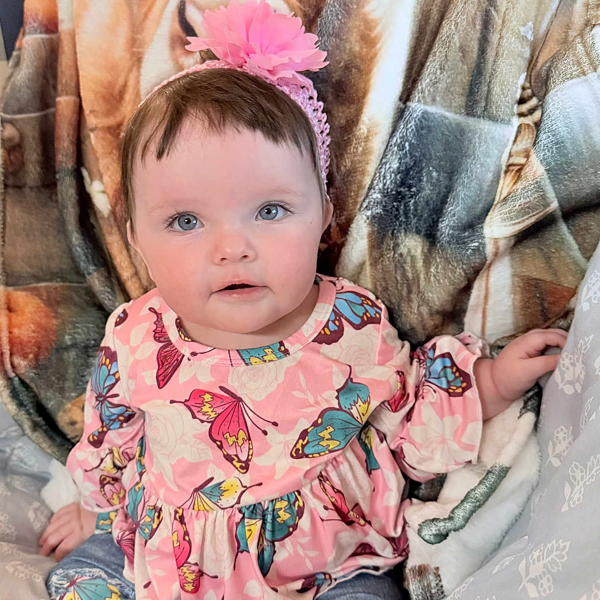 Lilyonna joined the competition — help win amazing prizes! baby, blanket, blue_eyes, butterfly_pattern, casual_wear, child, clothing, comfort, cozy, cute, face, flower, happy, indoor, infant, pink_headband, portrait, sitting, soft, young_child