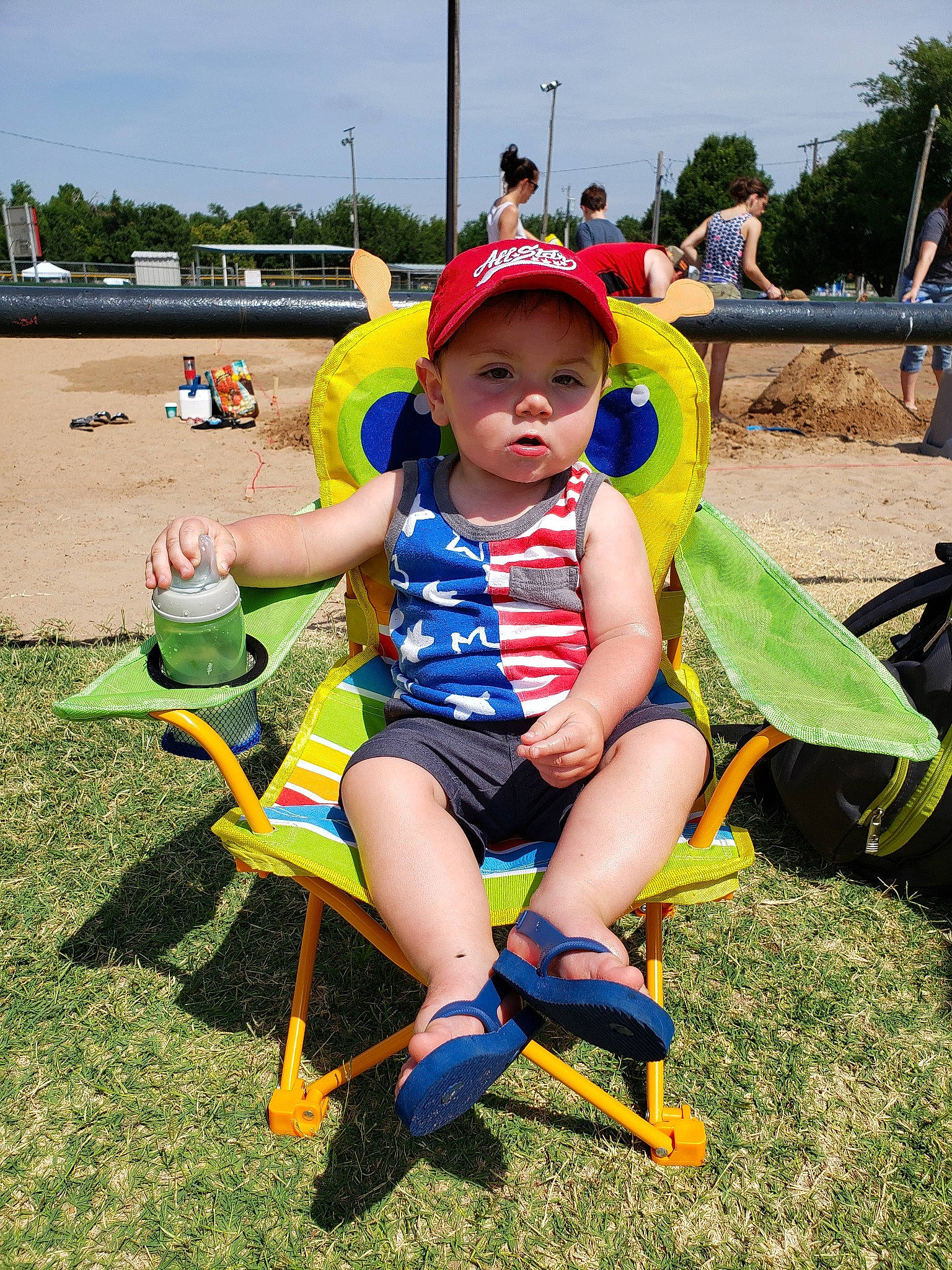 Daxtyn is registered to the contest to win money with this photo: child, fun, grass, leisure, lifejacket, person, personal_protective_equipment, plant, play, playground, recreation, sitting, smile, summer, toddler, tree, vacation, yellow