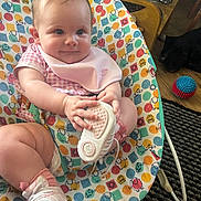 Isla-Mae is registered to the contest to win money with this photo: baby, infant, child, shoe, baby_seat, patterned_fabric, indoor, toy_ball, dog, floor, carpet, pink_clothing, bib, footwear, cute, smiling, person, home, furniture, curious