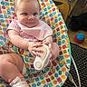 baby, infant, child, shoe, baby_seat, patterned_fabric, indoor, toy_ball, dog, floor, carpet, pink_clothing, bib, footwear, cute, smiling, person, home, furniture, curious