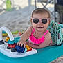 baby, baby_walker, beach, child, colorful, cute, fun, happy, outdoor, person, pink_swimsuit, play, sand, seat, smiling, summer, sunglasses, sunny, toys, vacation
