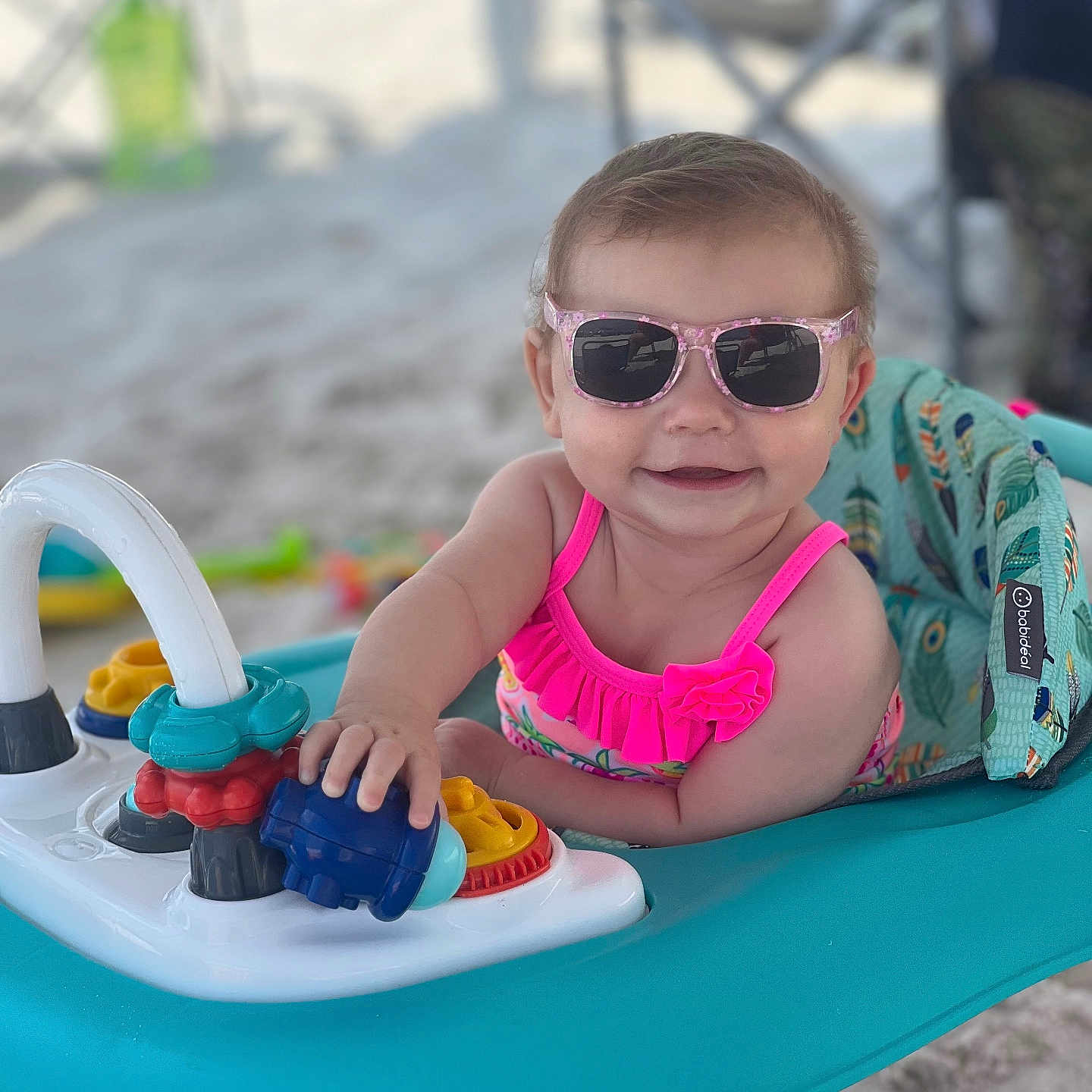 Kadi joined the competition — help win amazing prizes! baby, baby_walker, beach, child, colorful, cute, fun, happy, outdoor, person, pink_swimsuit, play, sand, seat, smiling, summer, sunglasses, sunny, toys, vacation