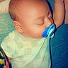 Asher is registered to the contest to win money with this photo: baby, pacifier, sleeping, infant, onesie, blue, heart_emoji, hand, skin, face, head, closeup, cute, child, resting, indoor, blanket, comfort, toddler, peaceful
