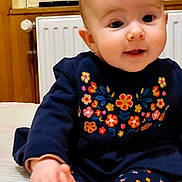 Coraline participe au concours pour gagner de l'argent avec cette photo : baby, infant, child, smiling, sitting, clothing, embroidered_flowers, navy_outfit, feet, hands, indoor, blanket, radiator, window, cute, portrait, face, happy, young_child, cozy