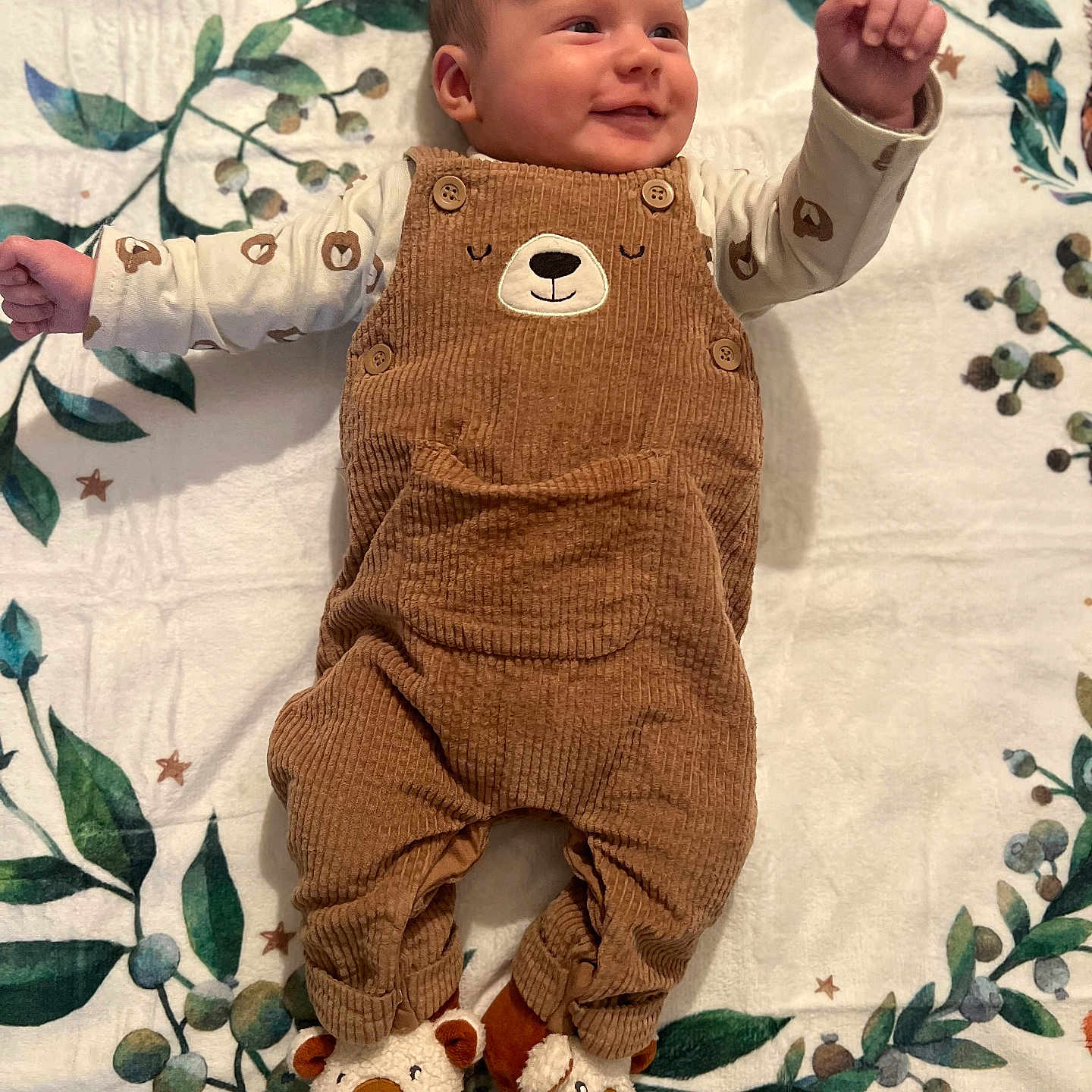 Léo participe au concours pour gagner de l'argent avec cette photo : adorable, baby, bear_design, blanket, brown_overalls, buttoned_overalls, child, cute, footwear, happy, indoor, infant, leaf_pattern, long_sleeve_shirt, lying_down, portrait, slippers, small_hands, smiling, soft_texture