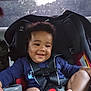 baby, barefoot, car_interior, car_seat, child, clothing, cute, face, hair, happy, infant, person, safety_harness, seat, seat_buckle, seatbelt, smile, transportation, window, young_child