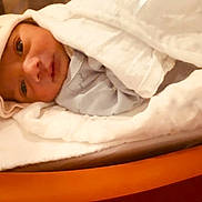 Sihan is registered to the contest to win money with this photo: newborn, baby, blanket, hat, sleepwear, face, infant, wrapped, bed, soft, cozy, cute, indoors, person, portrait, young_child, resting, warm, sleep, closeup