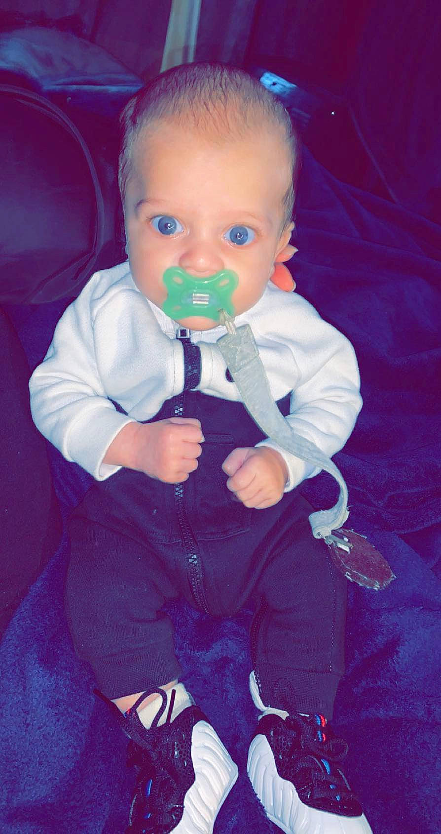 Kirby is registered to the contest to win money with this photo: baby, cheek, child, eye, formal_wear, fun, head, nose, person, play, product, purple, sitting, smile, suit, toddler