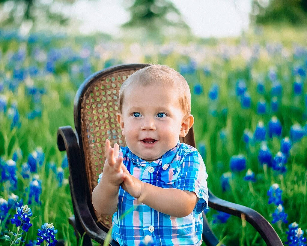 Cannon is registered to the contest to win money with this photo: azure, baby, baby_toddler_clothing, blue, eye, flower, grass, grass_family, grassland, green, happy, iris, leaf, people_in_nature, person, petal, plant, skin, smile, sunlight