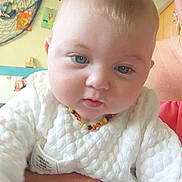 Manoë participe au concours pour gagner de l'argent avec cette photo : baby, child, face, blue_eyes, sweater, necklace, hand, adult, indoor, wall, decoration, picture_frame, colorful, cute, skin, portrait, person, closeup, holding, soft