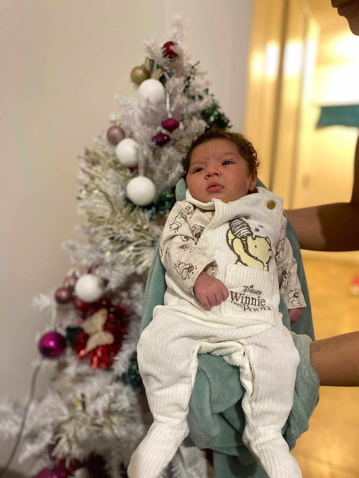Violetta a rejoint le concours — aidez-le/la à gagner de superbes lots ! baby, infant, winnie_the_pooh, pajamas, clothing, person, face, hands, christmas_tree, ornaments, holiday, indoor, decorations, blurred_background, cozy, cute, child, holding, festive, warm_lighting