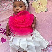 Kehlani joined the competition — help win amazing prizes! baby, infant, girl, headband, flower, pink, white, dress, blanket, playpen, milestone, wooden_sign, 3_months, cute, portrait, laying_down, indoors, child, smiling, face