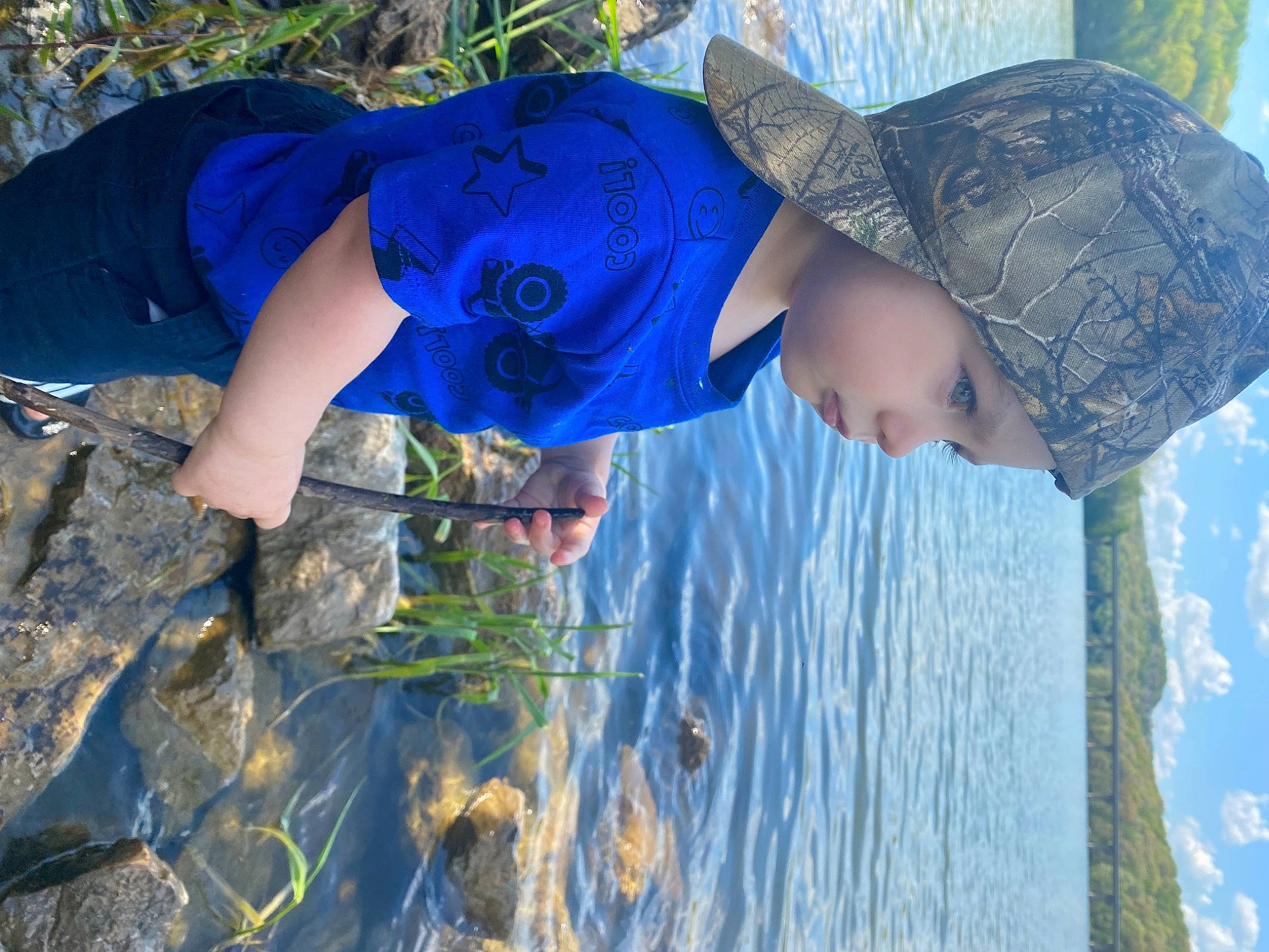 Brady is registered to the contest to win money with this photo: azure, blue, cap, cloud, electric_blue, fun, grass, grass_family, happy, hat, headwear, lake, leaf, leisure, people_in_nature, person, plant, recreation, sky, sun_hat