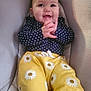 baby, infant, smile, clapping, polka_dot, navy_blue, yellow_pants, daisies, cute, happy, face, child, seated, cushion, indoor, portrait, clothing, hands, eyes, joyful