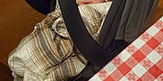Emma is registered to the contest to win money with this photo: baby, blanket, car_seat, plaid, tablecloth, indoor, smile, child, face, seat, wood, floor, shoe, person, warm, cute, infant, sitting, cozy, happy