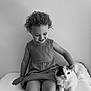 Aliya participe au concours pour gagner de l'argent avec cette photo : child, toddler, cat, pet, curly_hair, smiling, black_and_white, bench, indoor, cute, animal, feline, happy, portrait, young_child, friendly, calm, minimalist, monochrome, companion