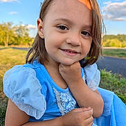 Elora joined the competition — help win amazing prizes! child, smile, blue_dress, outdoor, grass, sunlight, nature, puffy_sleeves, portrait, happy, young_girl, face, hand, daylight, person, casual, cute, scenic, closeup, innocence