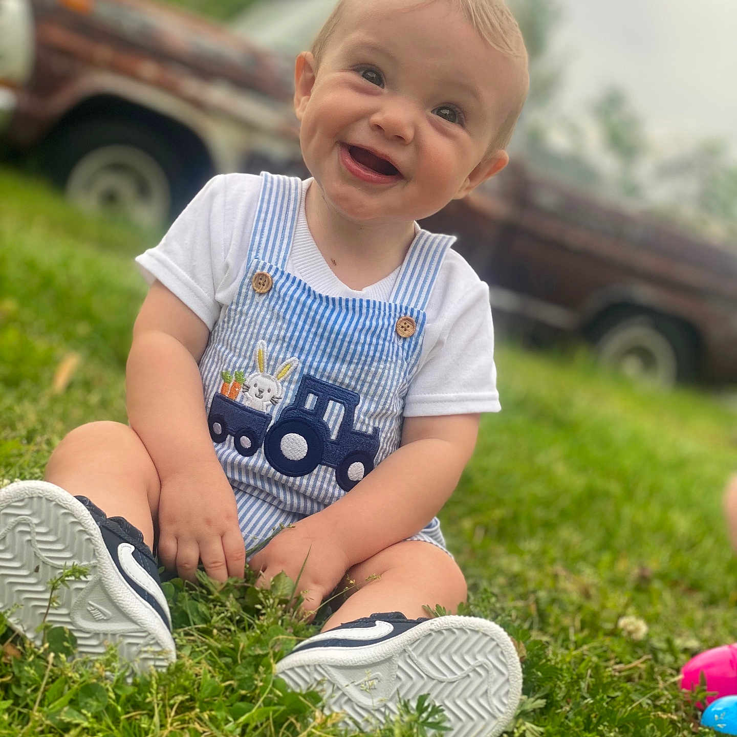 Grayson is registered to the contest to win money with this photo: ball, boy, child, clothing, face, football, footwear, grass, head, lawn, male, person, photography, plant, portrait, shoe, shorts, sitting, soccer, t_shirt