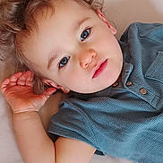 Justin participe au concours pour gagner de l'argent avec cette photo : toddler, child, face, blue_eyes, curly_hair, hand, shirt, portrait, close_up, cute, baby, skin, expression, indoor, lying_down, person, young_child, casual_clothing, relaxed, looking_at_camera