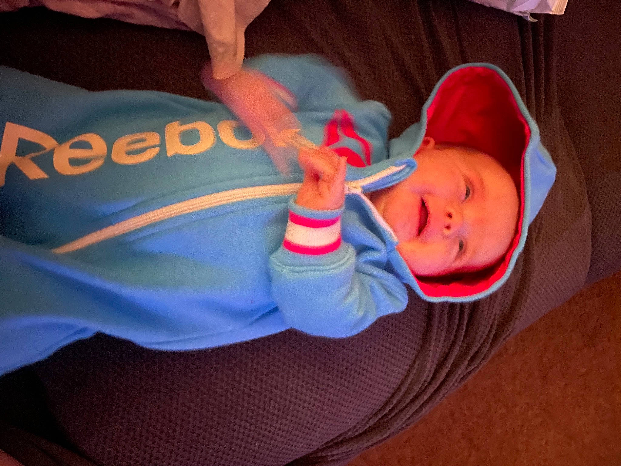 Madi is registered to the contest to win money with this photo: baby, baby_carriage, baby_products, baby_toddler_clothing, cap, car_seat, carmine, child, comfort, electric_blue, finger, fun, human_body, mouth, nail, orange, person, pink, sitting, thumb