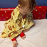 Alyocea is registered to the contest to win money with this photo: barefoot, bed, child, clothing, colorful, curly_hair, cute, headboard, indoors, infant, playful, polka_dots, red_headband, room, sitting, tiger_print, toddler, white_bed_sheet, yellow_gown, young_child