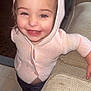 baby, child, clothing, couch, cute, face, floor, golden_shoes, happy, home, hoodie, indoor, knitwear, leaning, person, pink, portrait, small, smiling, toddler