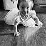 Piper Jay is registered to the contest to win money with this photo: baby, black_and_white, child, crawling, curly_hair, cute, dress, face, floor, hands, happy, indoor, motion, person, playful, portrait, smiling, toddler, wooden_floor, young_child