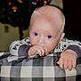 Cayson is registered to the contest to win money with this photo: baby, blue_eyes, child, hand, pillow, checkered_pattern, indoors, portrait, face, sucking_thumb, cute, young, infant, resting, curious, soft_lighting, background_blur, festive_lights, clothing, person