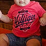 Liam is registered to the contest to win money with this photo: toddler, child, boy, sitting, portrait, face, serious, looking_at_camera, red_shirt, graphic_tshirt, shorts, indoors, furniture, wood, red_surface, phone_screenshot, status_bar, navigation_bar, blond_hair, casual_clothing