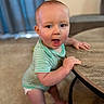 Wyatt joined the competition — help win amazing prizes! baby, child, infant, onesie, table, wood, carpet, indoor, standing, holding, face, expression, curtains, blurred_background, cute, person, skin, furniture, home, young