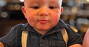 Wyatt joined the competition — help win amazing prizes! baby, child, face, portrait, indoor, table, clothing, suspenders, blue_shirt, hands, expression, young_child, cute, person, head, skin, cheeks, short_hair, focus, warm_lighting