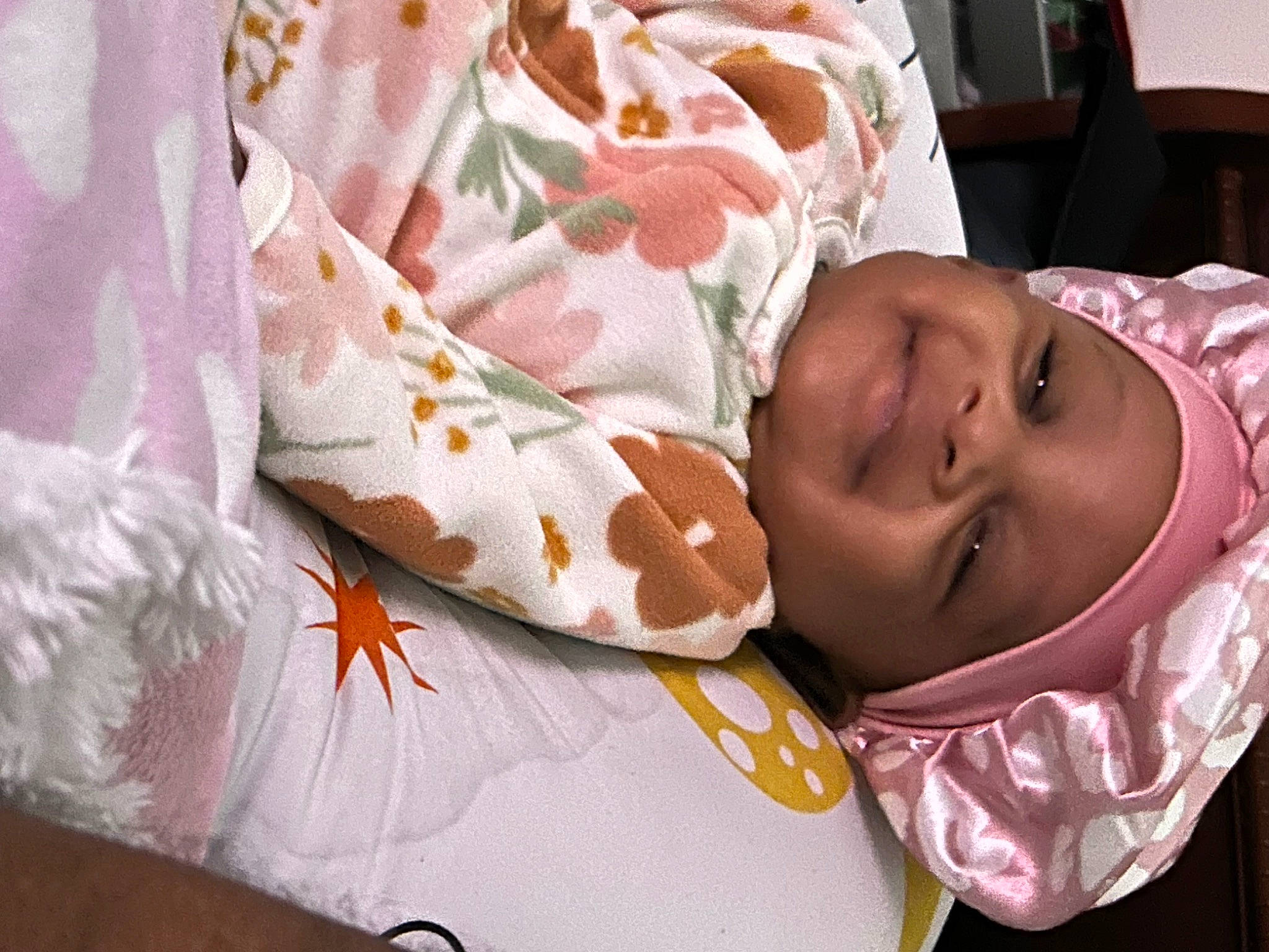 Mariah is registered to the contest to win money with this photo: baby, baby_products, baby_toddler_clothing, child, comfort, eye, finger, happy, headgear, headwear, human_body, joy, linens, neck, pattern, peach, person, petal, room, skin