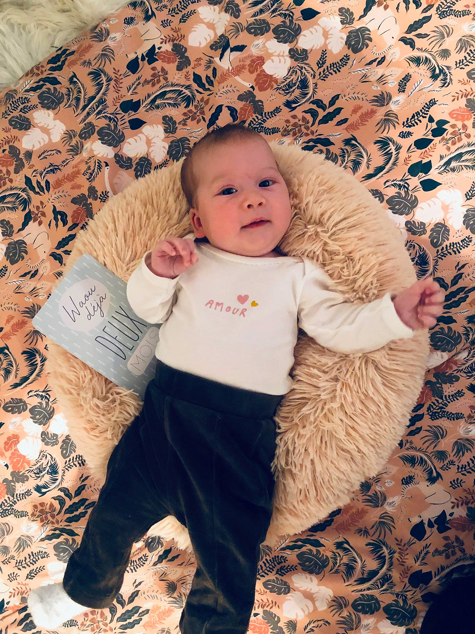 Lila a rejoint le concours — aidez-le/la à gagner de superbes lots ! baby, baby_toddler_clothing, cheek, child, comfort, fashion_accessory, happy, linens, pattern, person, photo_shoot, portrait_photography, sitting, sleeve, t_shirt, thigh, toddler