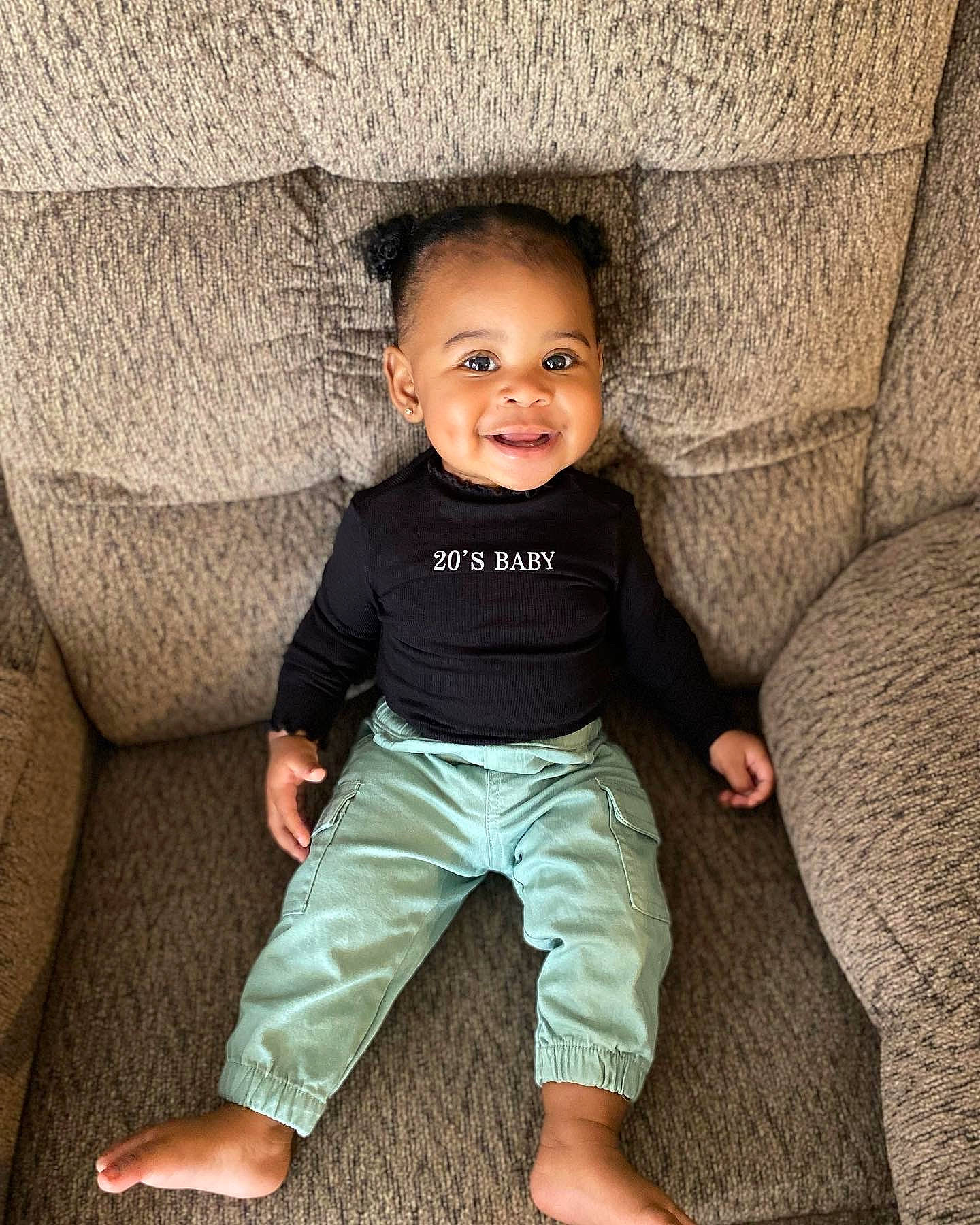 Ahziyah is registered to the contest to win money with this photo: baby, baby_toddler_clothing, cheek, comfort, couch, eye, face, facial_expression, flash_photography, happy, human, joy, leg, organ, person, skin, sleeve, smile, standing, tints_and_shades