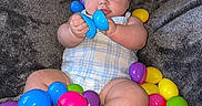 Kaelahni is registered to the contest to win money with this photo: baby, child, infant, bow, headband, plastic_eggs, colorful, toy, blanket, soft, cute, sitting, indoors, playful, chubby, feet, hands, clothing, portrait, happy