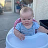 Kaelahni is registered to the contest to win money with this photo: baby, child, high_chair, blue_shirt, outdoor, daylight, curious, face, infant, sitting, tray, blurry_background, concrete, garage, person, young_child, short_hair, pink_chair, casual, cute
