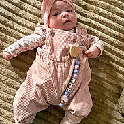 Lya participe au concours pour gagner de l'argent avec cette photo : baby, infant, pink_clothing, headband, pacifier_clip, corduroy, blanket, texture, lying_down, cute, child, soft_lighting, indoor, portrait, apparel, footwear, smiling, small_hands, face, cozy