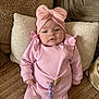 Lya participe au concours pour gagner de l'argent avec cette photo : baby, infant, pink_clothing, headband, bow, cushion, blanket, cozy, soft_texture, indoor, portrait, child, young, cute, lying_down, warm_colors, comfortable, clothing, person, face