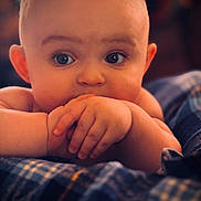 Wade joined the competition — help win amazing prizes! baby, infant, face, hands, eyes, skin, plaid_blanket, close_up, portrait, cute, curious, child, young, resting, soft_lighting, indoor, cozy, warm_colors, person, expression